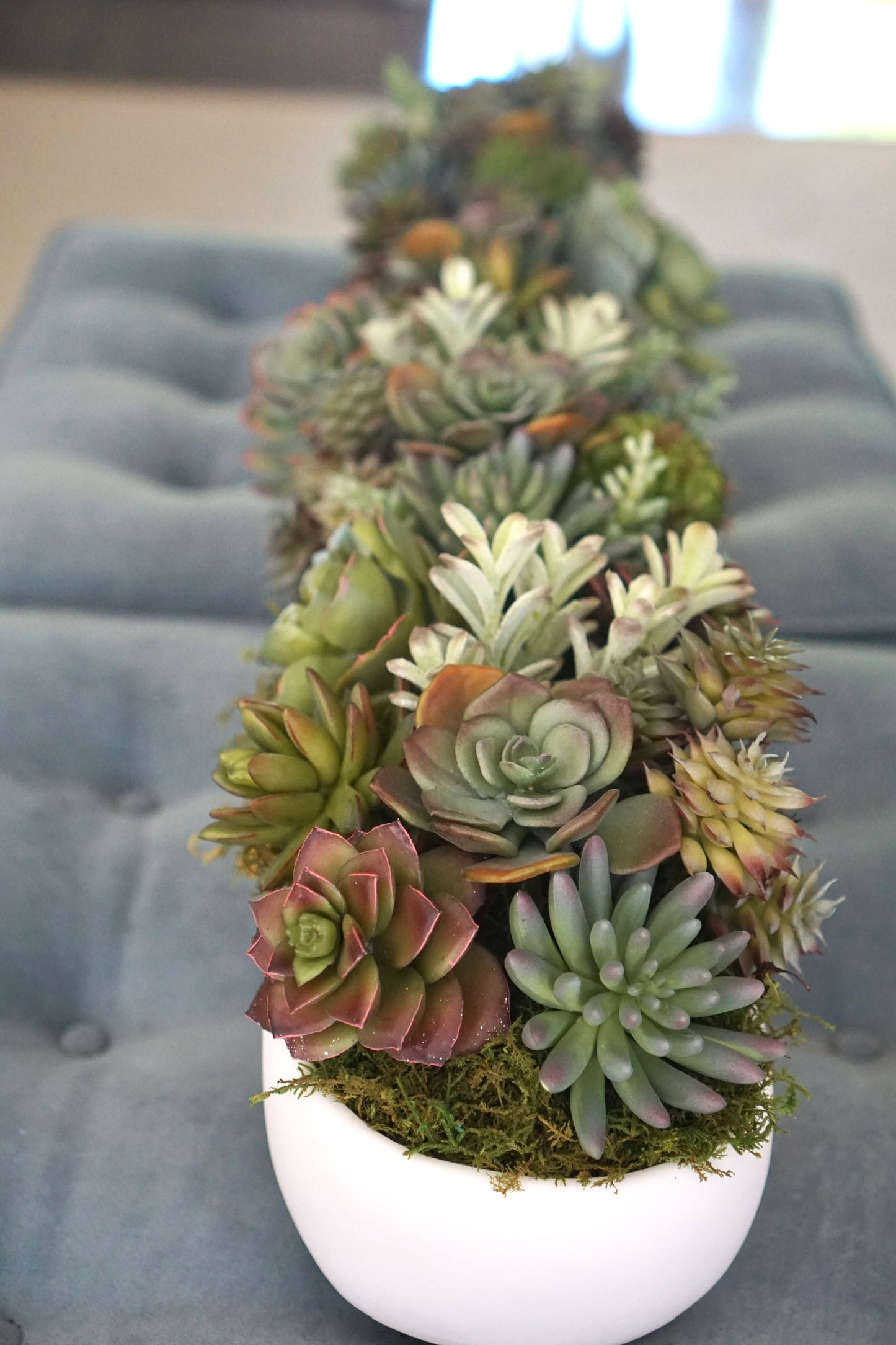 A long white centerpiece with layers and layers of Artificial Succulents