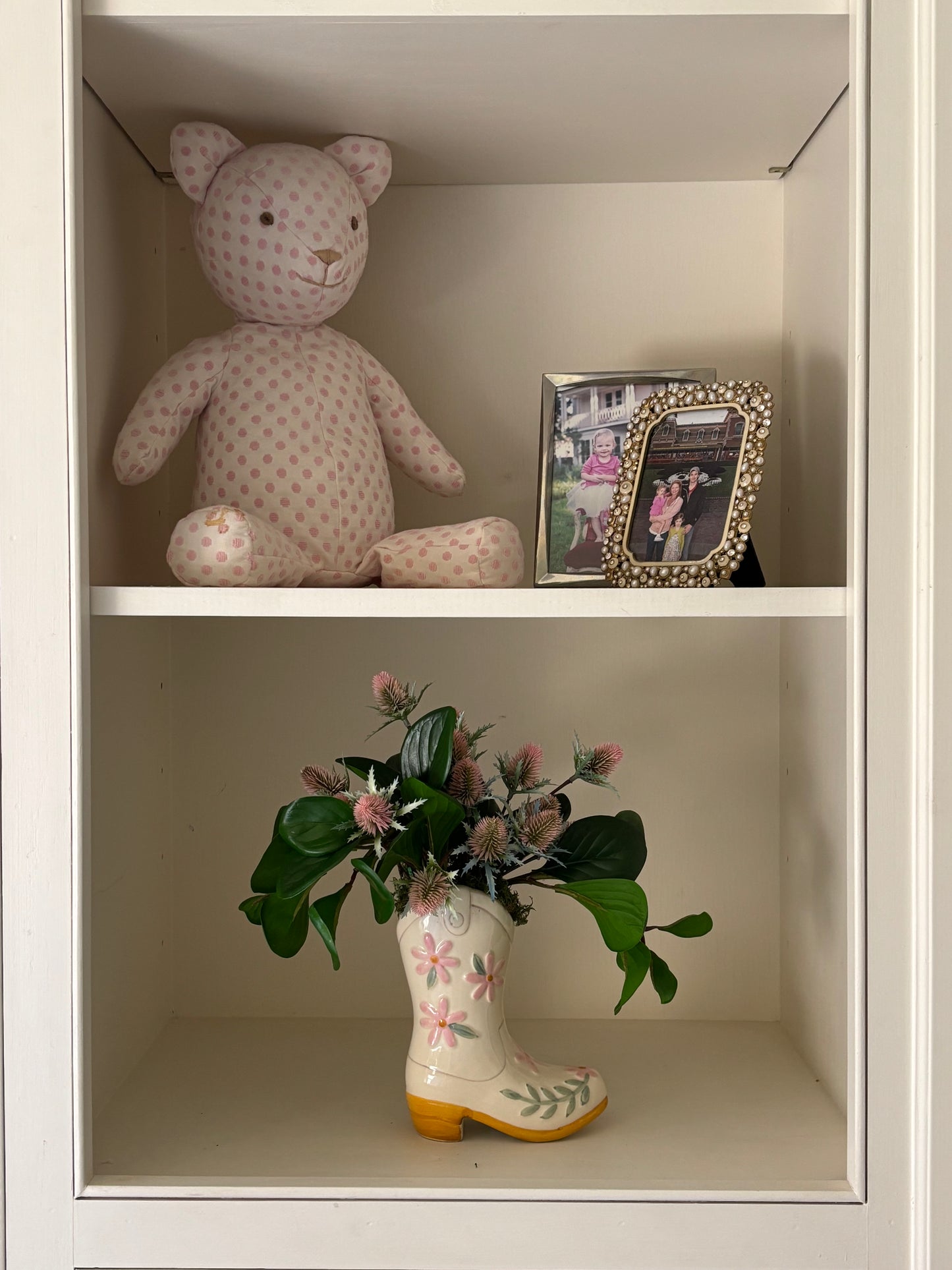 boot vase with florals in bookshelf